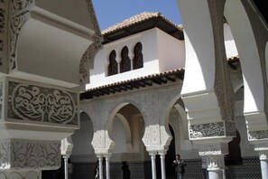 Une structure architecturale aux motifs complexes, alternant le blanc et le noir, agrémentée d’arches et surmontée d’un toit recouvert de tuiles.