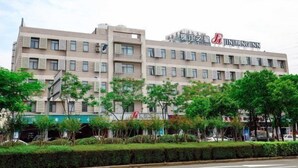 A multi-story hotel building with a sign reading "Jinjiang Inn".