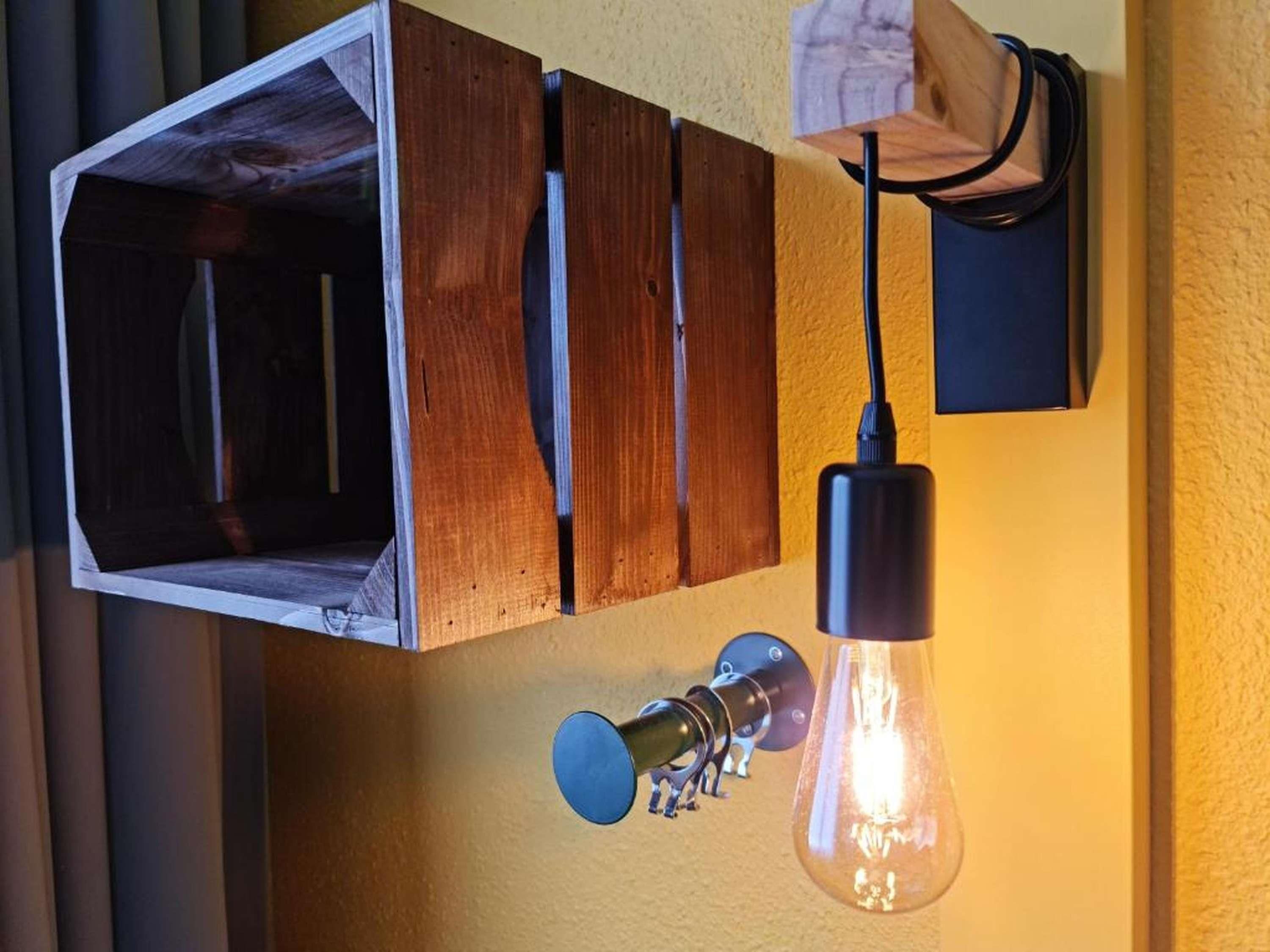 A wall-mounted wooden cabinet with a light fixture and a visible electrical outlet.