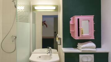 A bathroom with a glass shower enclosure, a white sink, and a mirror with a pink frame.