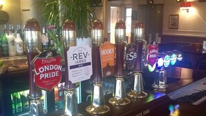 Un bar con varias griferías de cerveza, incluyendo Fuller's London Pride y Rev. James.