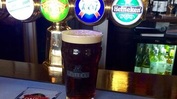 A bar with beer taps and a glass of beer.