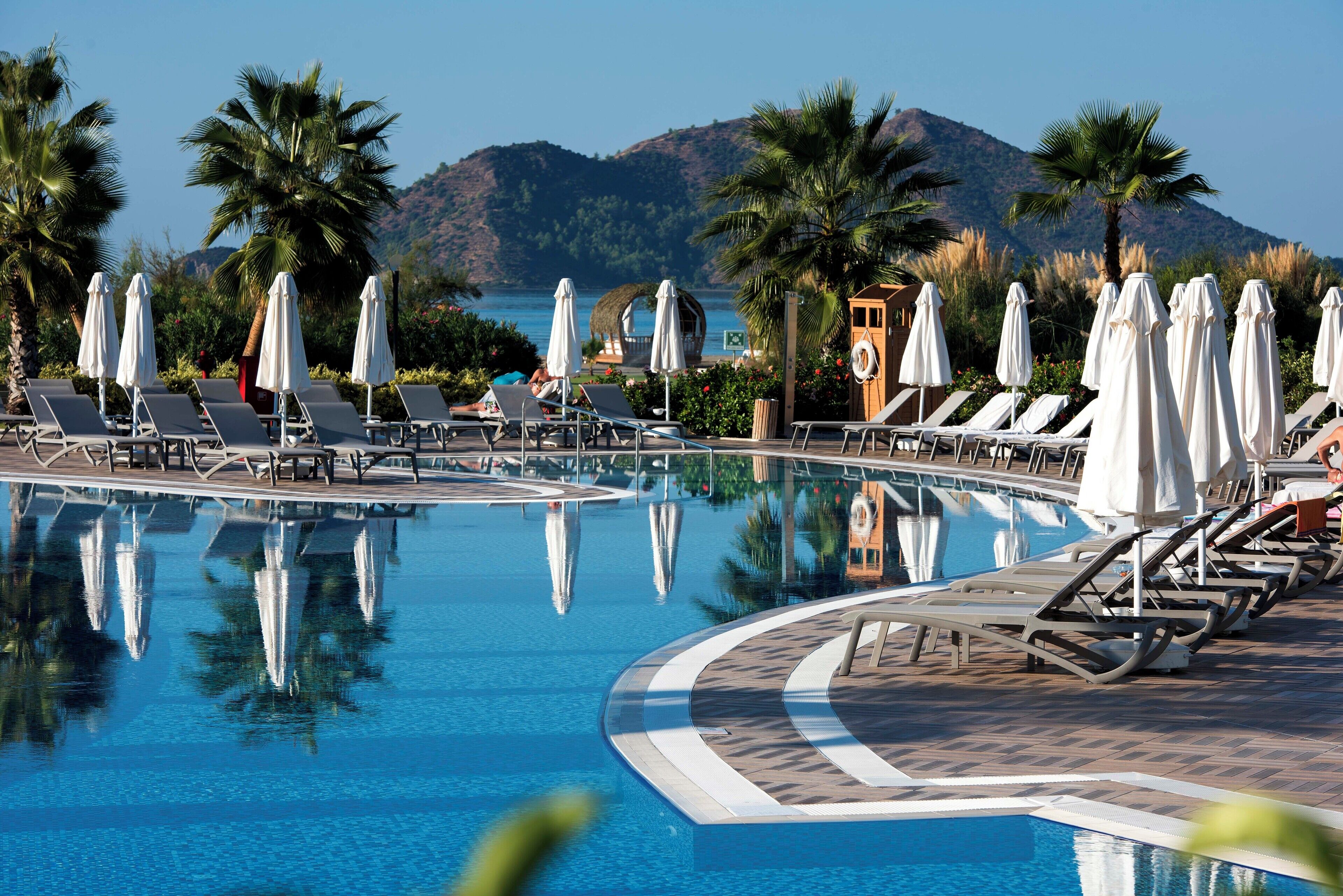Una piscina techada, una piscina al aire libre, sombrillas
