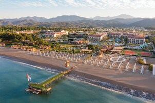 En la playa, sillas reclinables de playa, sombrillas, toallas de playa