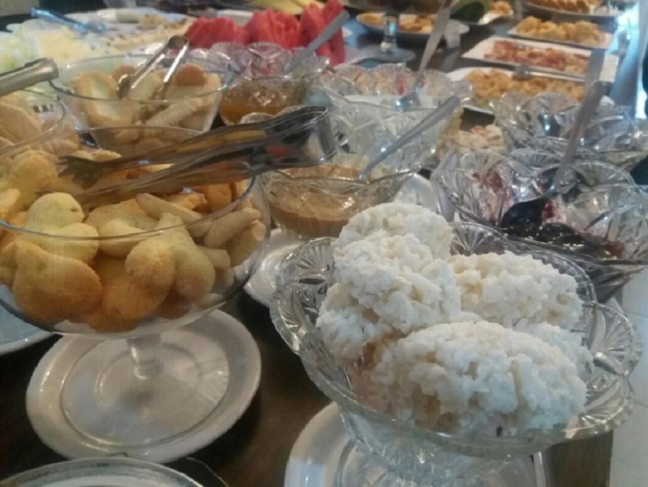 A buffet with various food items in glass dishes, including bread, rice, and other dishes.
