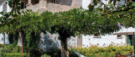 Une maison dotée d’un patio couvert, d’un hamac et d’un jardin bien entretenu.
