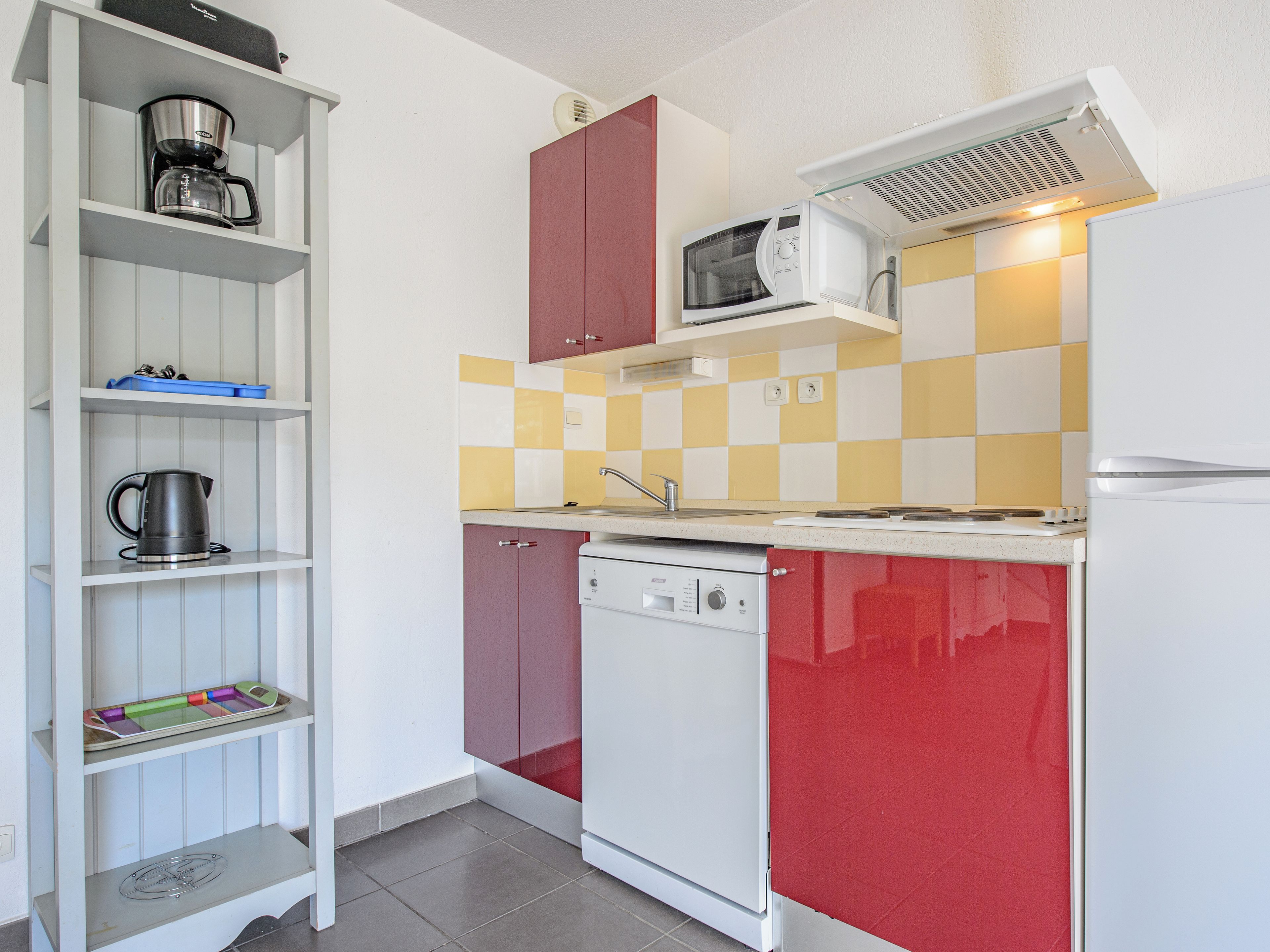 A compact kitchen with a microwave, coffee maker, and a dishwasher.