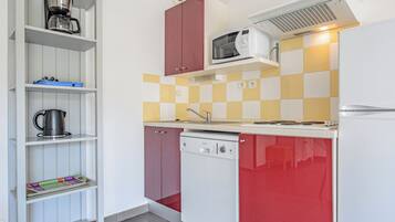 A compact kitchen with a microwave, coffee maker, and a dishwasher.