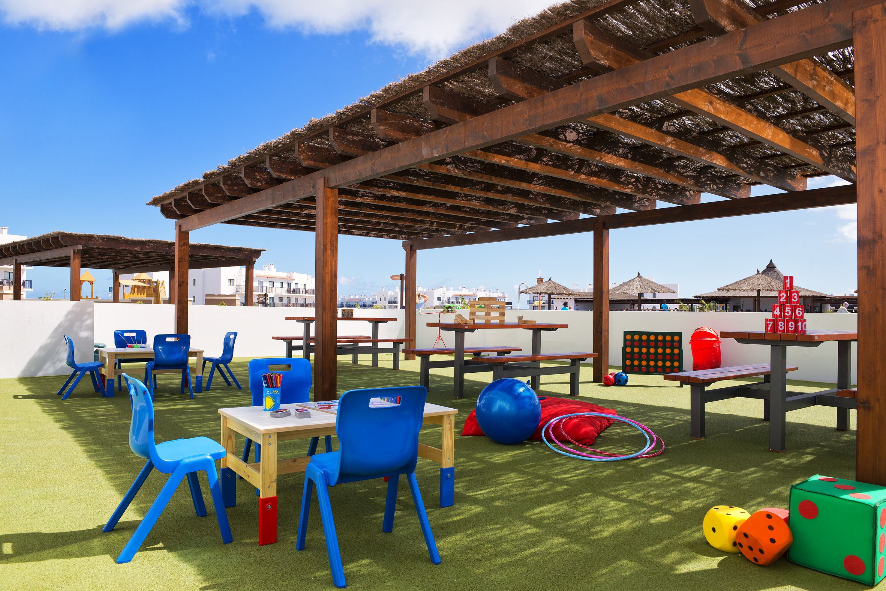 An outdoor play area with tables, chairs, and colorful toys.