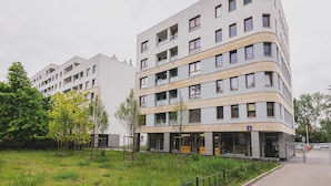 Un moderno edificio a più piani con balconi, un ingresso al piano terra e un cartello che indica che si tratta di un hotel.