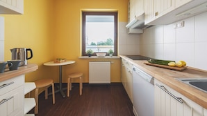 Una cucina compatta con un piano di lavoro in legno, un piccolo tavolo da pranzo e una finestra con vista.