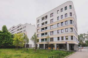 Un moderno edificio a più piani con balconi, un ingresso al piano terra e un cartello che indica che si tratta di un hotel.