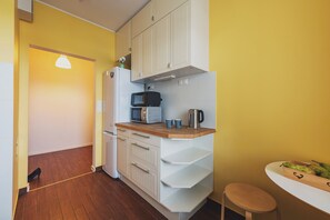 A compact kitchen with white cabinets, a microwave, a toaster, and a coffee maker. - P&O Apartments Namyslowska (Warsaw)