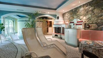 Un salón soleado con dos sillones reclinables, una pared de piedra y una chimenea.