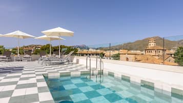 Una piscina al aire libre de temporada, sombrillas