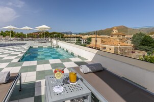 Una piscina al aire libre de temporada, sombrillas, tumbonas