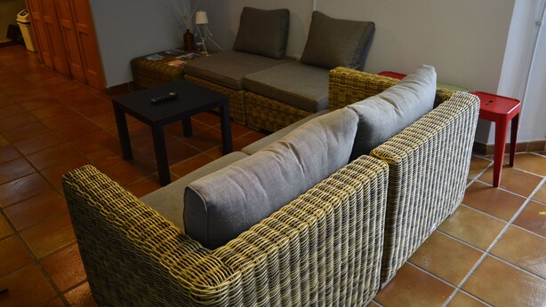 A living room with a sofa, a small table, and a red stool. - Albergue O Fogar de Teodomiro (Santiago de Compostela)
