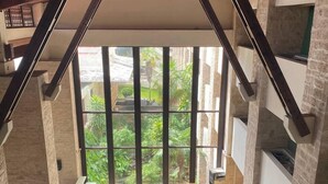 Un atrium espaiós amb alts sostres i grans finestres que ofereixen vistes a la verdura exterior.