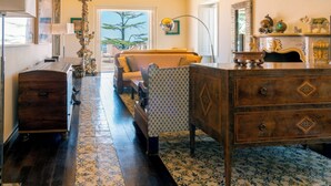 A spacious room with a patterned floor, a wooden chest, a patterned armchair, a sofa, and a dresser with drawers. - Capo Santa Fortunata (Sorrento)
