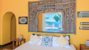 A room with a large bed, a decorative mirror, and a view of the sea. - Capo Santa Fortunata (Sorrento)