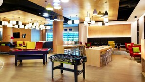A modern lounge area with a pool table, foosball table, and seating arrangements. - Aloft Dongguan Dynamic Town (Shenzhen)