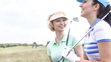 Deux personnes sur un terrain de golf, l’une tenant un club de golf.
