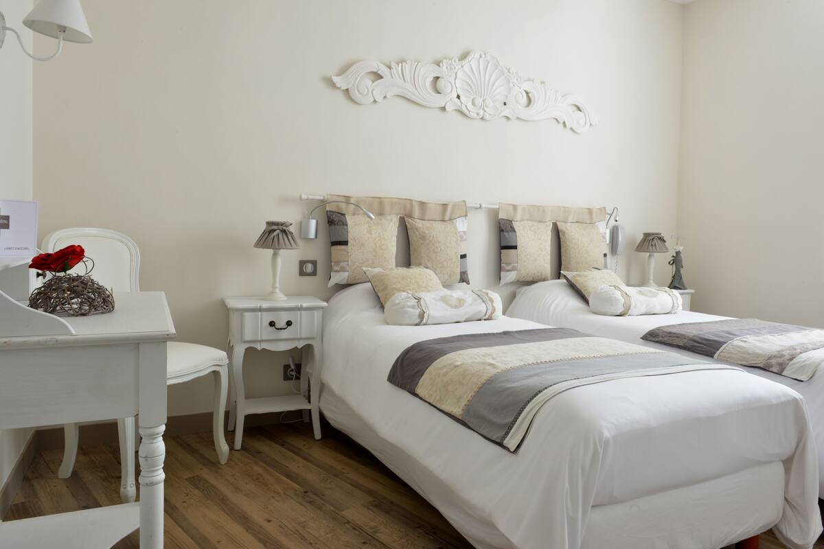 Une chambre à coucher avec un lit double, des tables de chevet, une lampe et un élément décoratif mural.