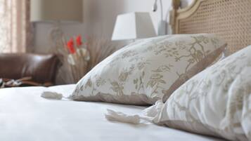 A neatly made bed with floral patterned pillows and a headboard.