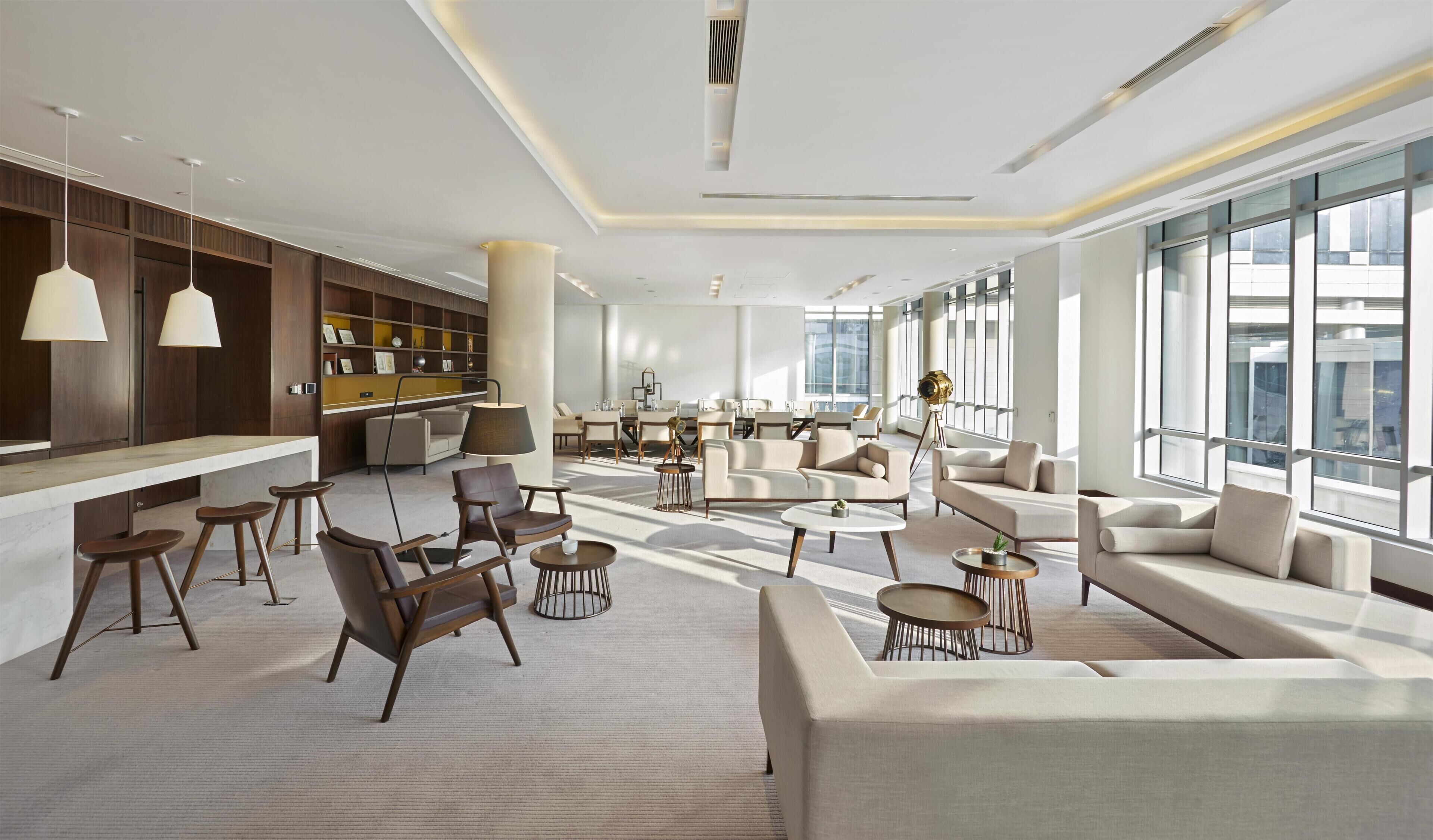 Un amplio salón con asientos, un bar y una estantería.
