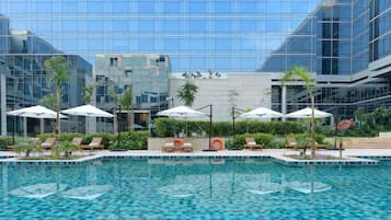 Piscine extérieure, parasols de plage, chaises longues