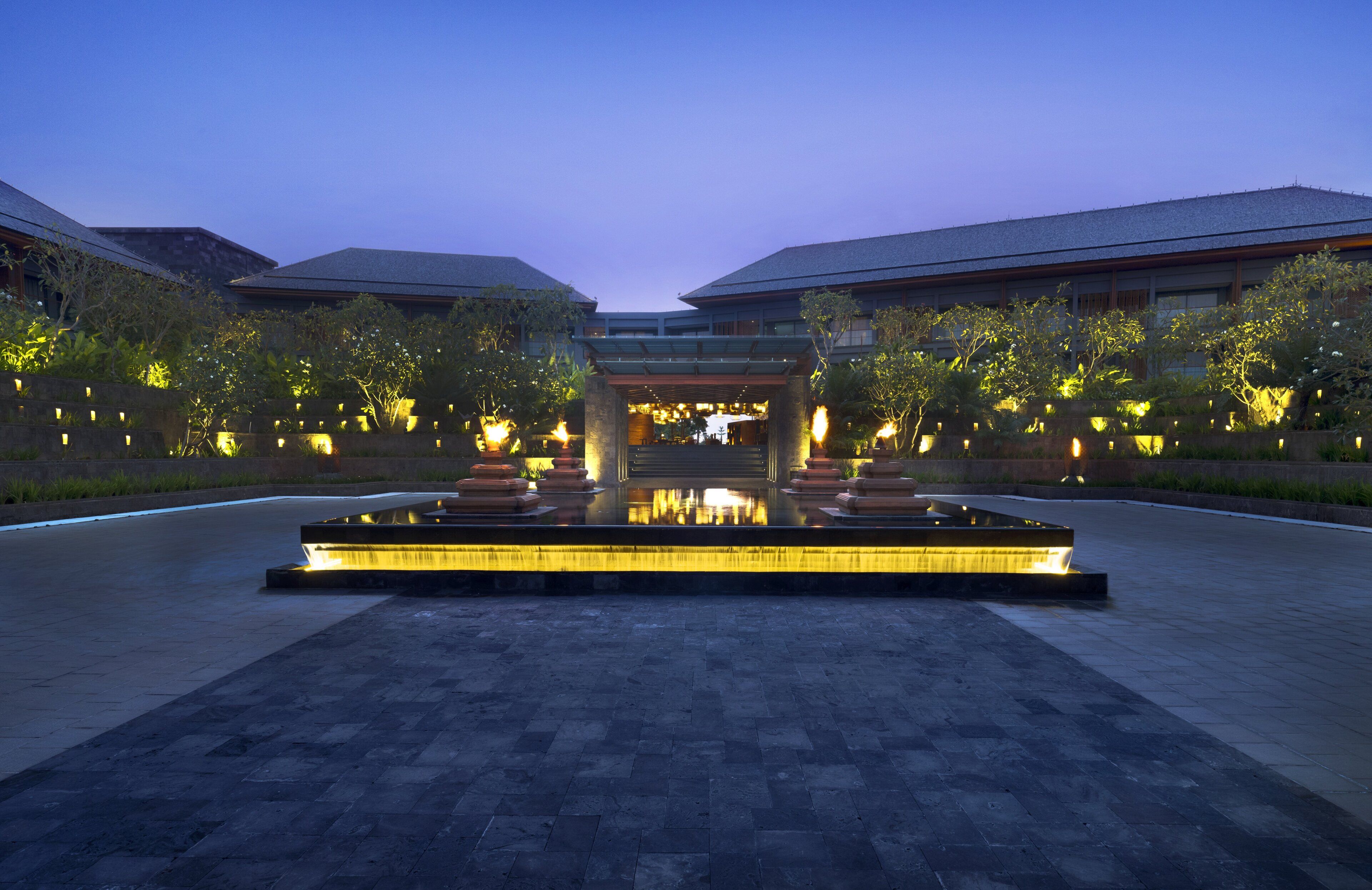 A courtyard with a water feature and a building entrance.