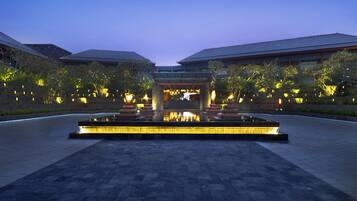 A courtyard with a water feature and a building entrance.