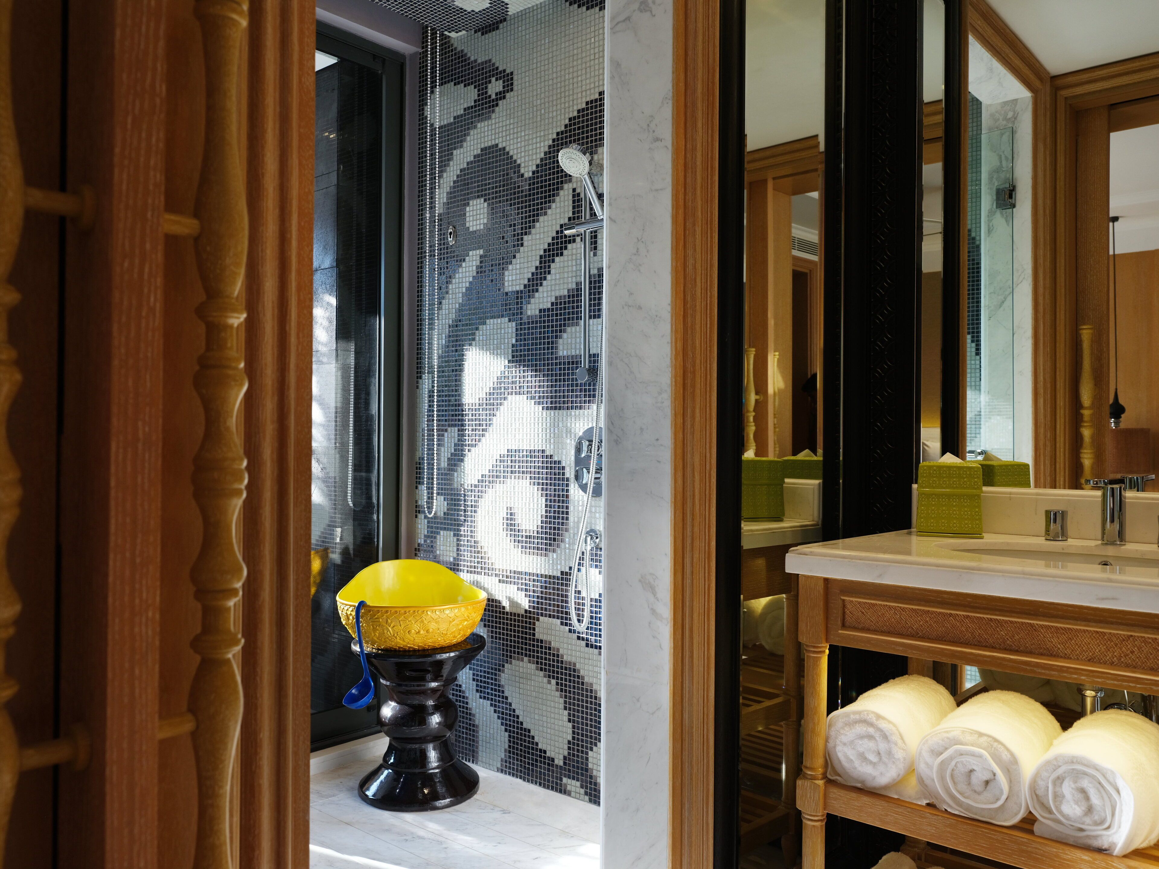 A bathroom with a marble sink, wooden vanity, and a mirror.