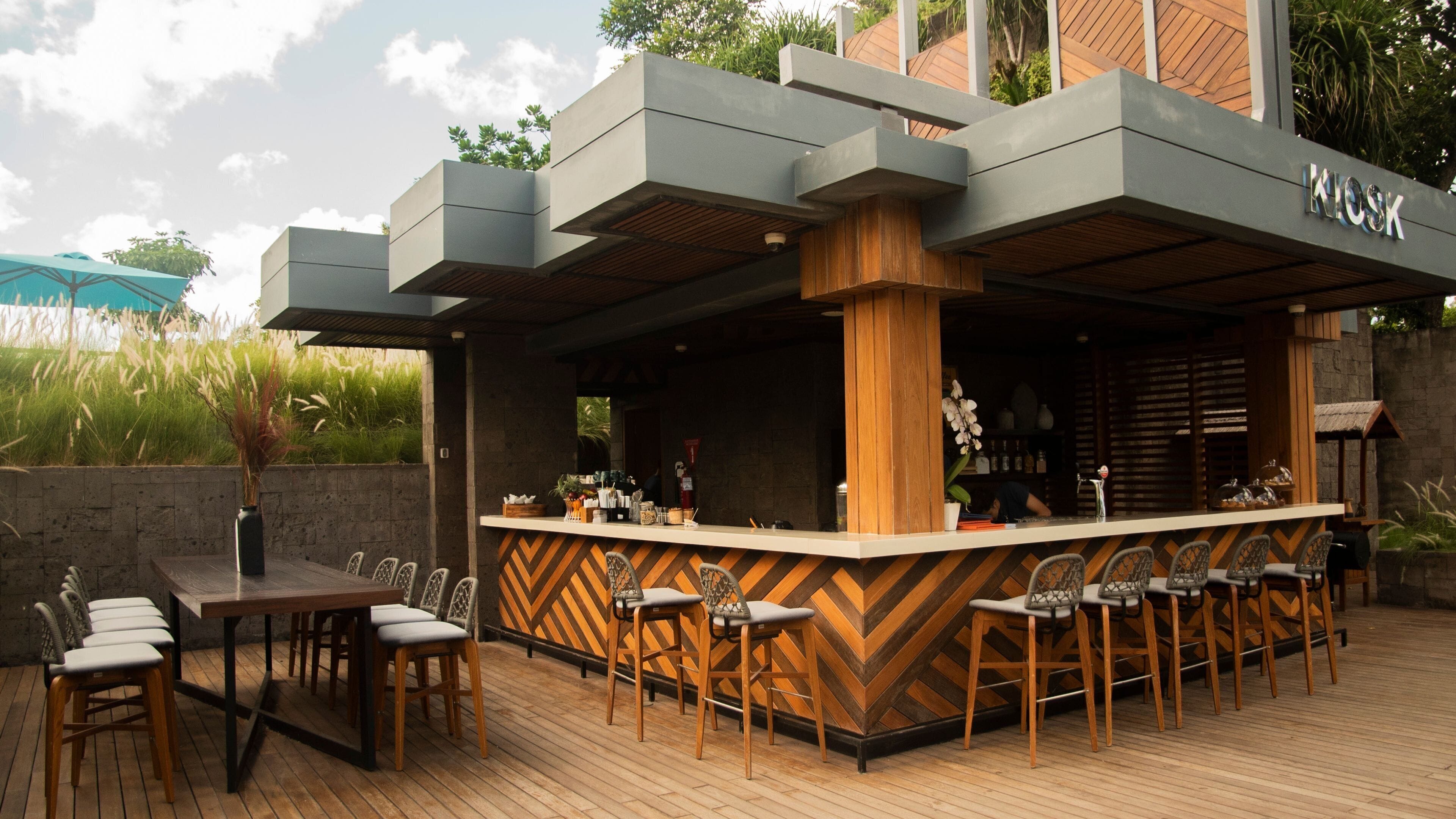 An outdoor bar area with a wooden deck, bar counter, and seating.