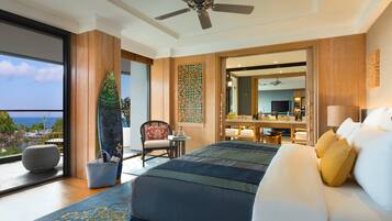 Un dormitorio con cama, una silla, una mesa y vistas al océano.
