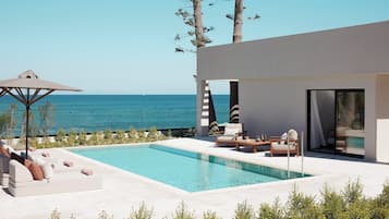 Relax by the pool surrounded by tall trees and a stunning ocean view.