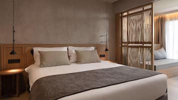 A modern hotel room with a large bed, a bedside table, a lamp, and a view of the outside through a window with curtains.
