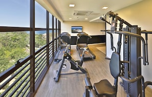 Ein Fitnessraum mit Laufbändern, Rudergerät und einer Gewichtbank.