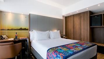 Une chambre d’hôtel équipée d’un lit, d’un bureau, d’une chaise et d’un téléviseur.
