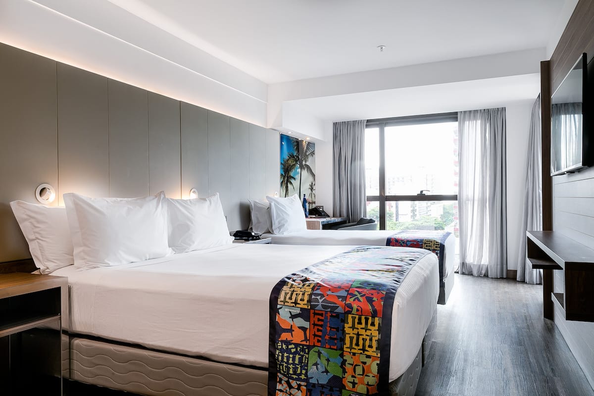 Deluxe Triple Room | Minibar, in-room safe, desk, blackout drapes