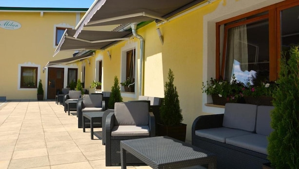 A hotel patio with outdoor seating and potted plants. - Pension Milan (Zell am See)