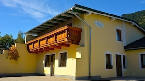 A yellow building with a wooden balcony and a sign that reads "Milan Pension". - Pension Milan (Zell am See)