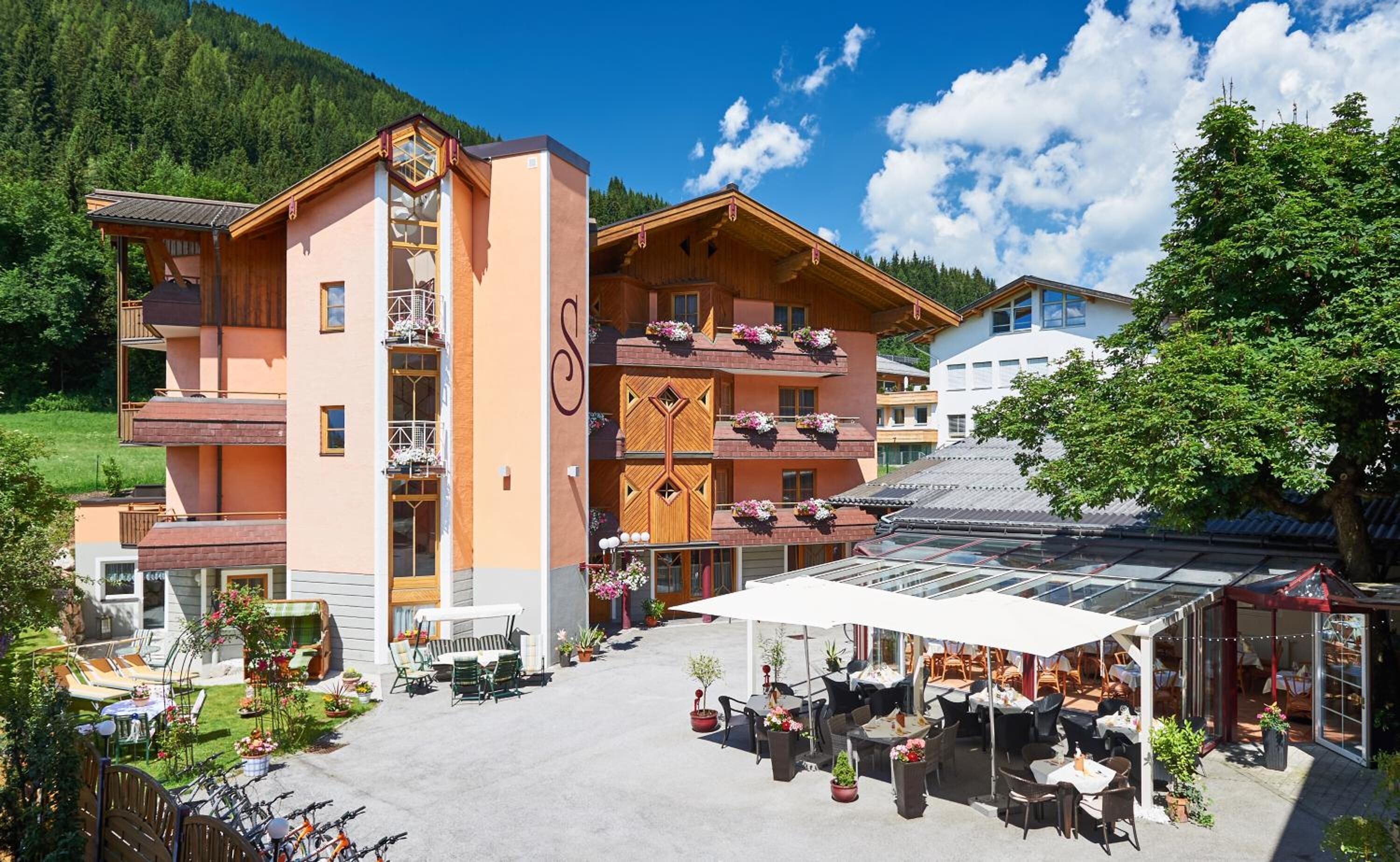 A multi-story hotel with outdoor seating and a covered patio area.