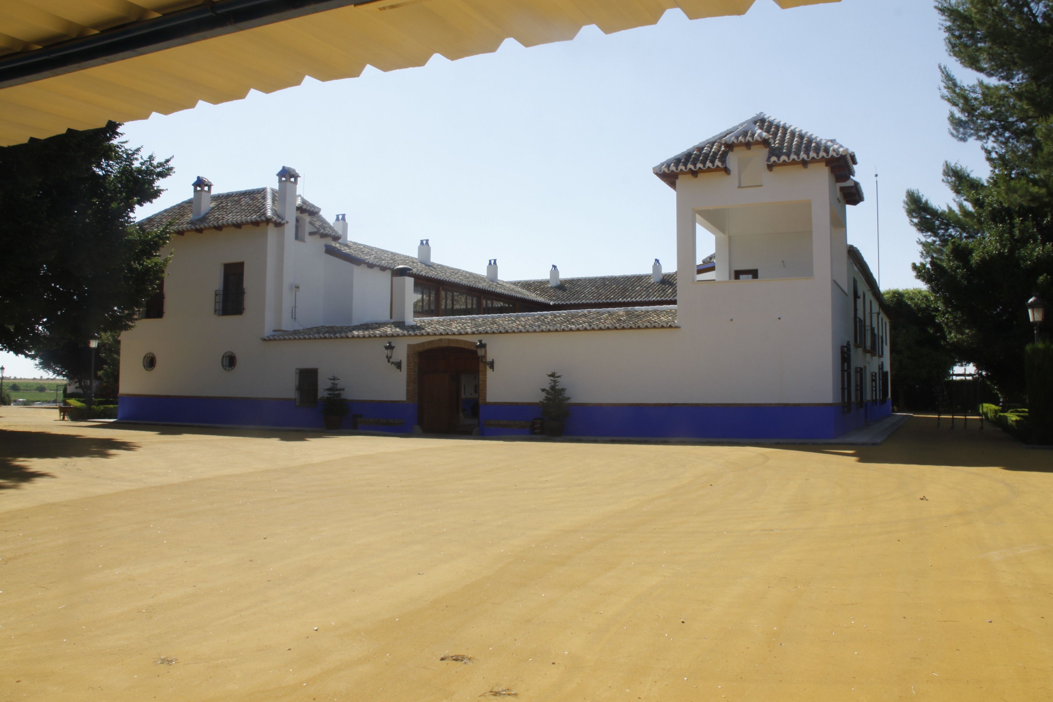 A building with a white facade, blue trim, and a tiled roof.