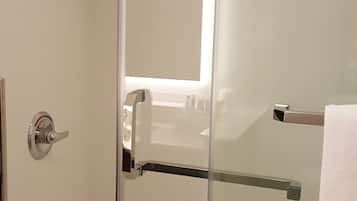 Een douche met glazen wanden, een handdouche en een handdoekhouder.