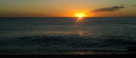 A sunset over a calm sea with a clear horizon.