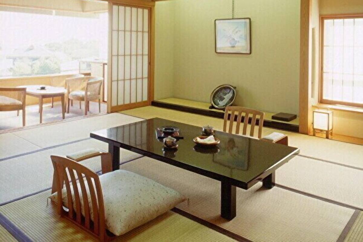 A traditional Japanese room with tatami flooring, a low table, and shoji screens.