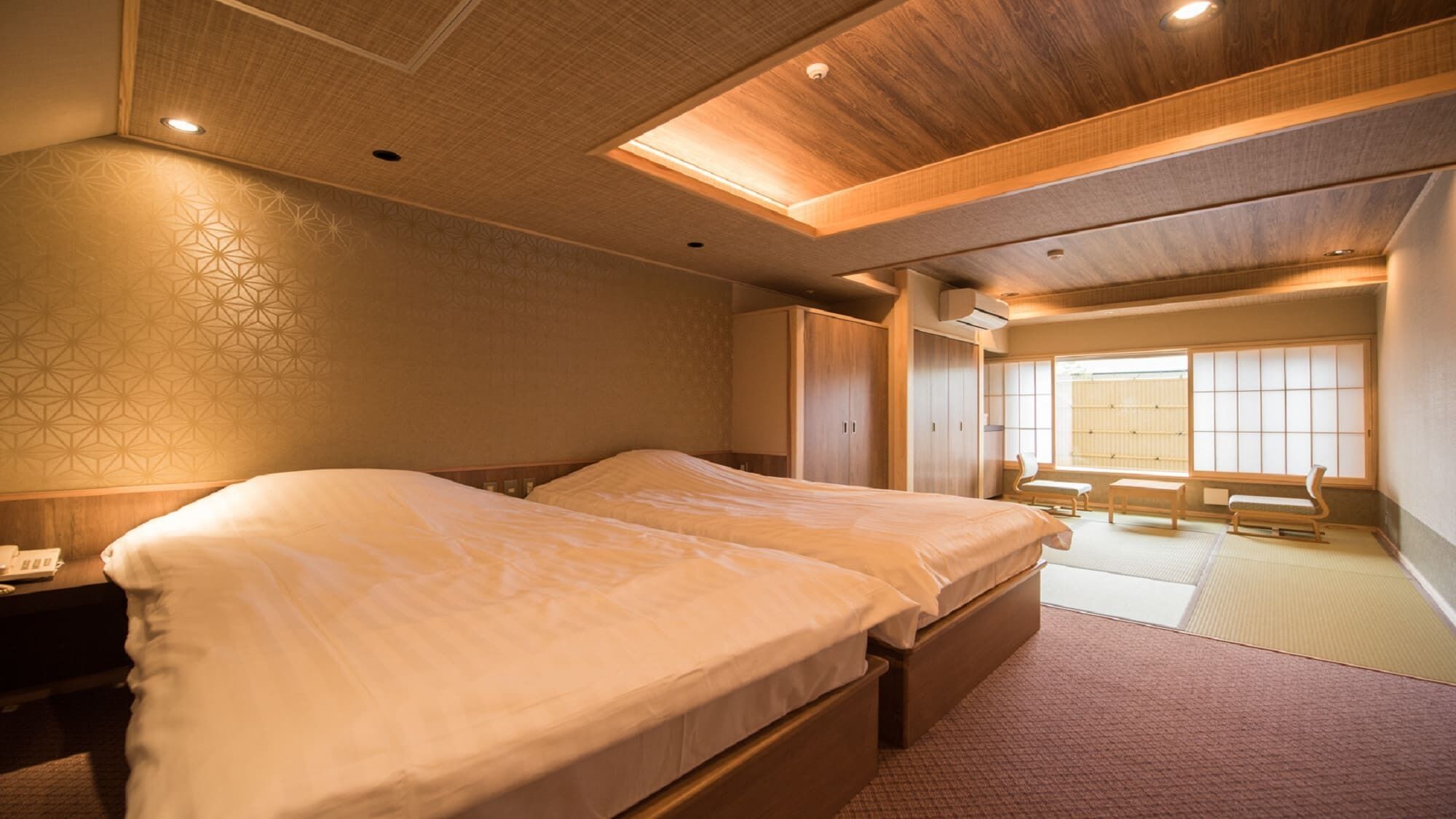 A hotel room with a large bed, wooden ceiling, and a view of a traditional Japanese room.