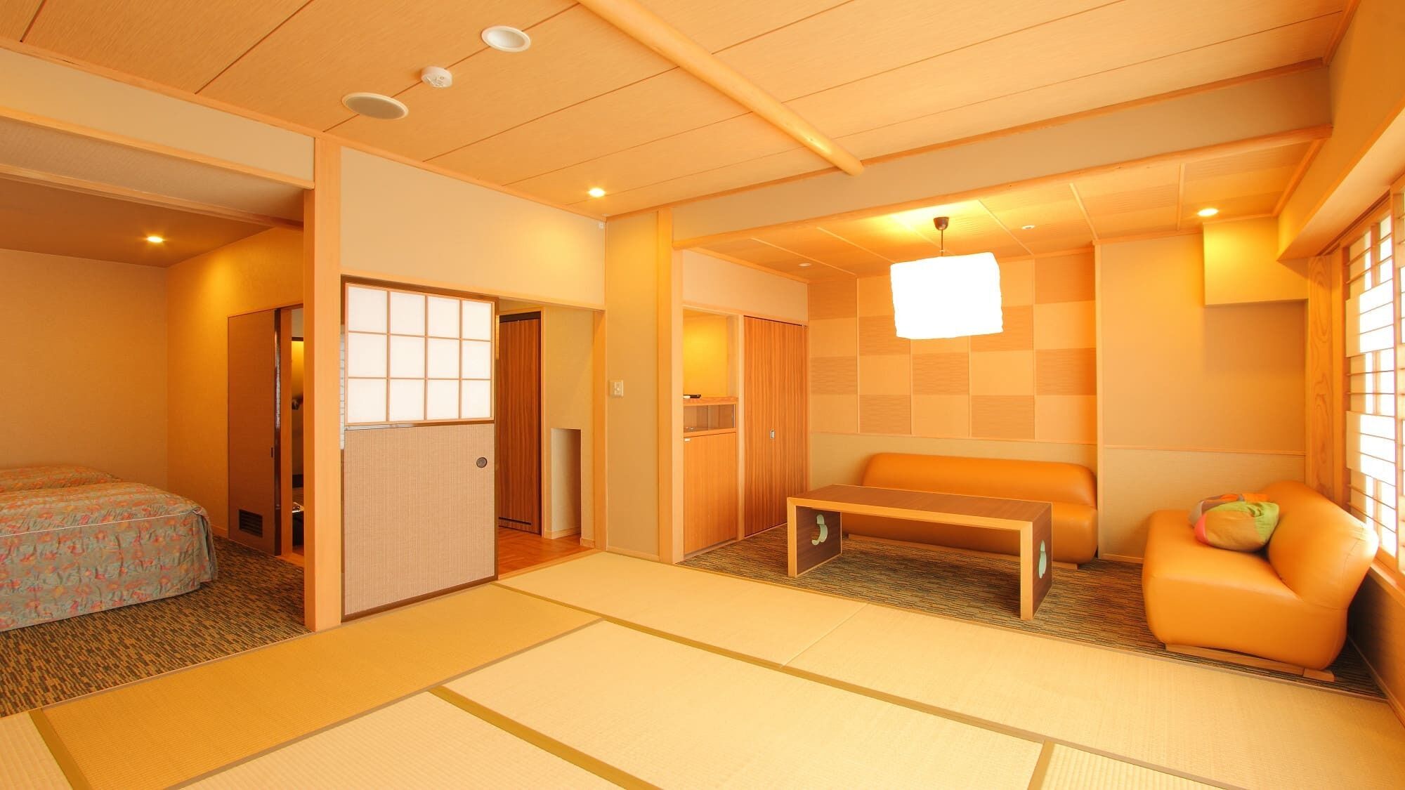 A traditional Japanese-style room with tatami flooring, a low wooden table, a cushioned bench, and sliding doors.