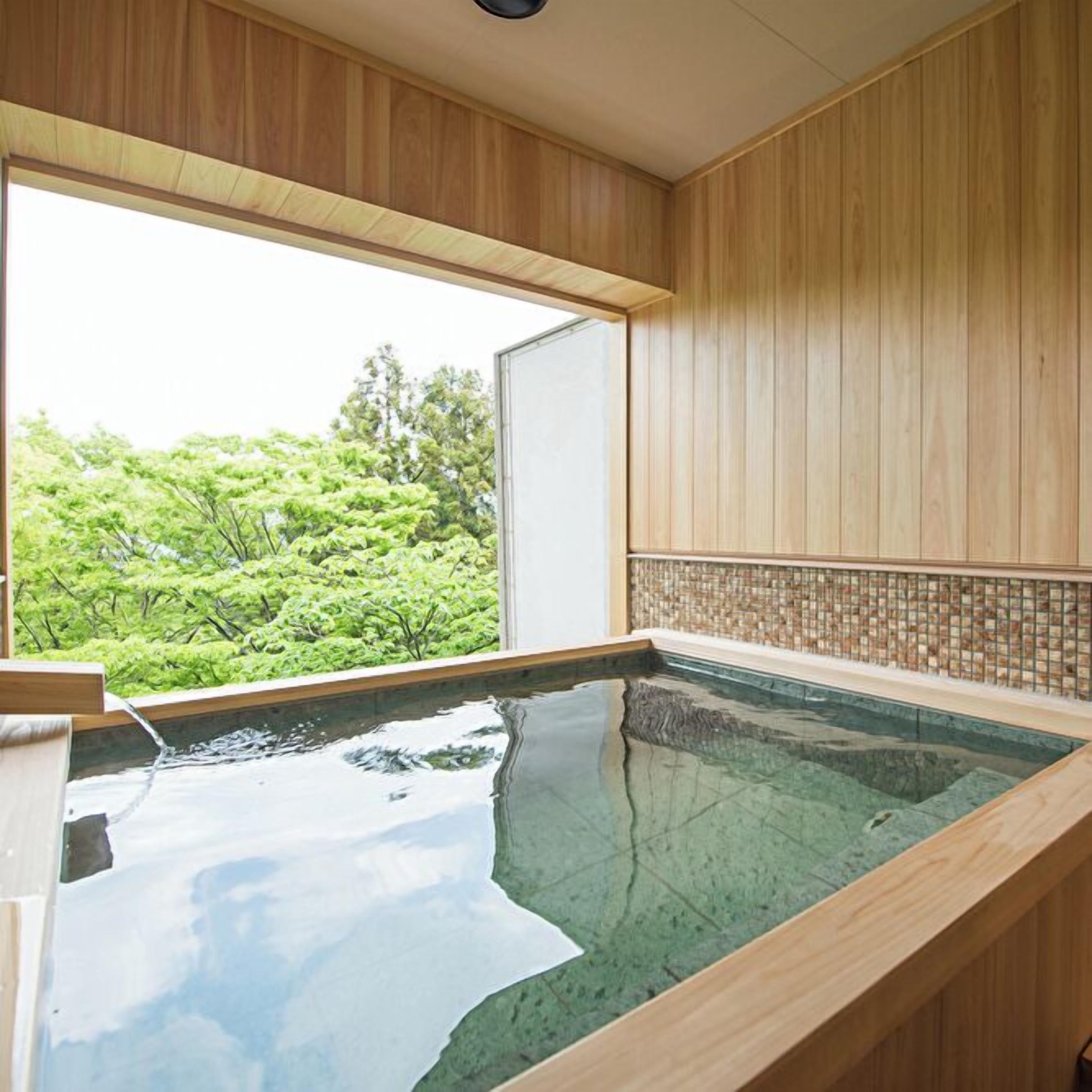 A wooden interior with a large window overlooking a lush garden.